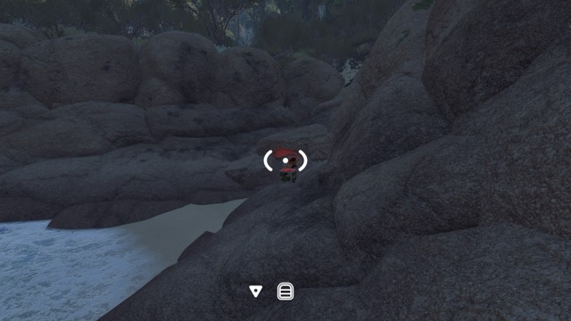 A reward box is concealed among large rocks on the beach